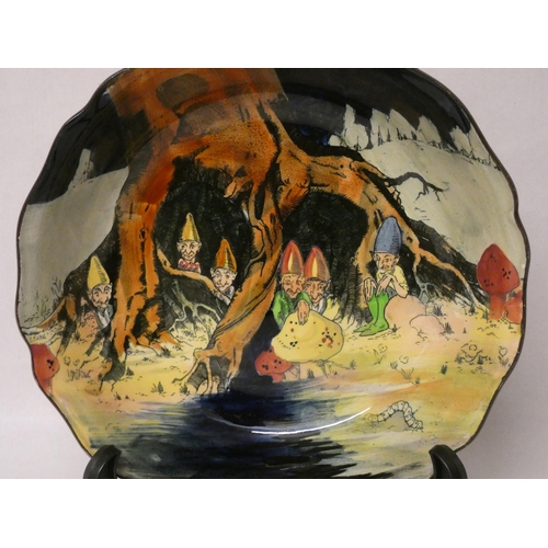 209 - A Charles Noke for Royal Doulton gnomes fruit bowl decorated with gnomes hiding amongst tree roots a... 