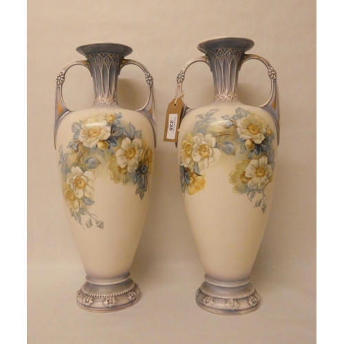 235 - A pair of continental porcelain twin handled vases, decorated with roses with gilt highlights. 40 cm... 