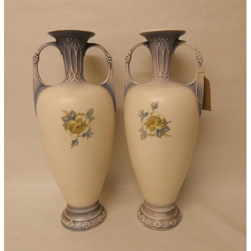 235 - A pair of continental porcelain twin handled vases, decorated with roses with gilt highlights. 40 cm... 