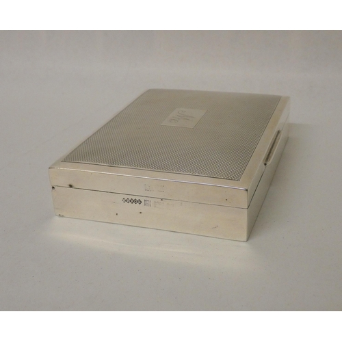 514 - A rectangular silver table top cigarette box with an engine turned hinged lid, engraved initial W. 1... 