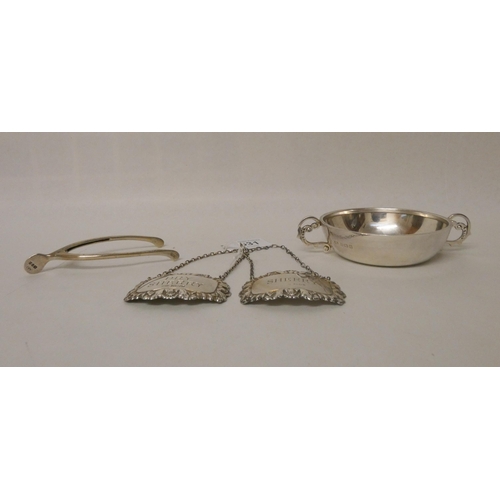 531 - A collection of small silver items - two decanter labels, spur shaped sugar nips and a wine taster. ... 