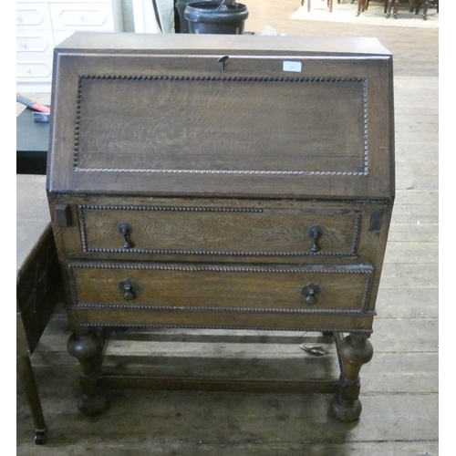 87 - An oak bureau with two drawers under standing on bulbous legs. 2'6