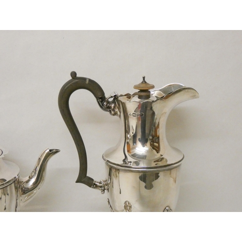 525 - A four piece silver tea service, with ebony handles and standing on hoof feet, two pieces hallmarked... 