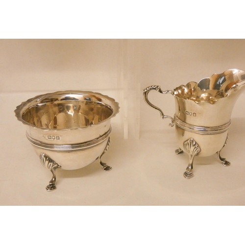 525 - A four piece silver tea service, with ebony handles and standing on hoof feet, two pieces hallmarked... 