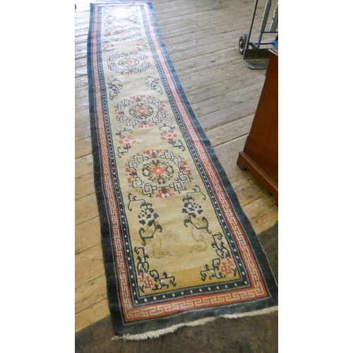 100 - A long figured fawn and patterned woollen carpet runner, aprrox. 15' long