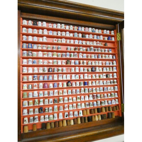 3 - A mahogany glazed wall hanging display cabinet full of assorted thimbles and a quantity of other box... 