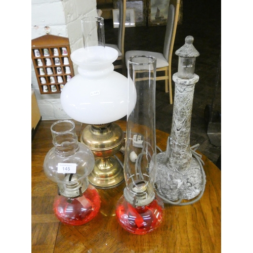 145 - Three assorted oil lamps and a lighthouse style serpentine marble lamp