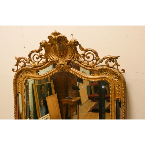 337 - A large Georgian style bevelled wall mirror in an ornate gilt frame with carved decoration over, 63