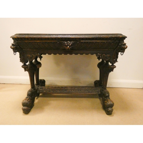 343 - A Victorian carved oak centre table fitted one drawer, carved with lion masks and on a dolphin style... 