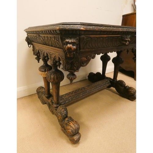 343 - A Victorian carved oak centre table fitted one drawer, carved with lion masks and on a dolphin style... 