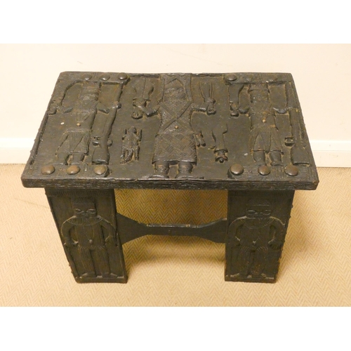 353 - An unusual tribal ebonised carved occasional table, carved with figures