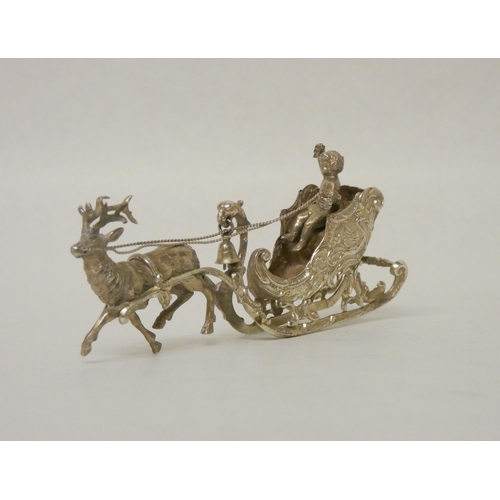 538 - A miniature silver novelty reindeer drawn sleigh. 9cm long