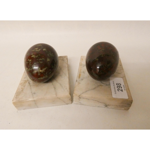 298 - A pair of serpentine and marble eggs on marble bases