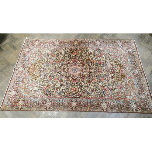 394 - A Persian carpet decorated with floral designs and central medallion in pinks and reds measuring 95