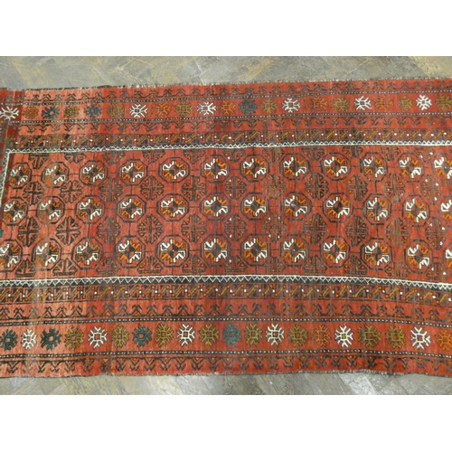 396 - A modern Persian Balouch style rug, decorated with medallions on a red ground measuring 79