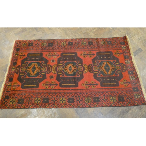 397 - A modern Persian design red ground carpet decorated with three medallions  measuring 79