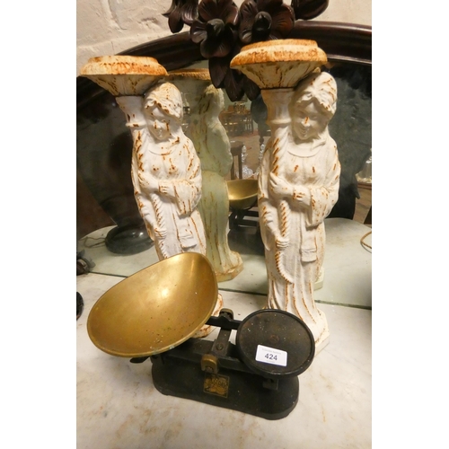 424 - A pair of heavy cast iron candle holders modelled as two religious ladies together with a set of bra... 