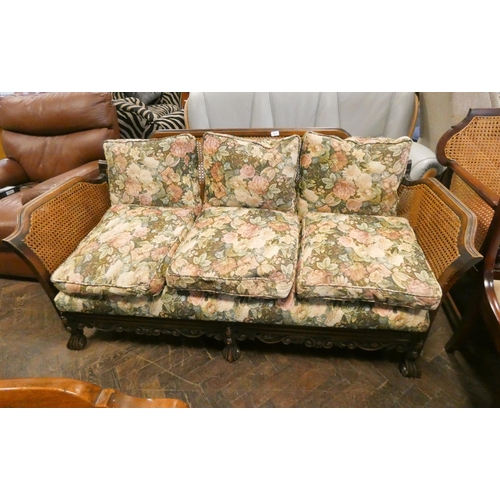 309 - A Bergere three seater sofa with floral cushions