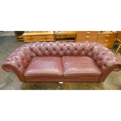 389 - A large two seater Chesterfield buttoned sofa upholstered in Oxblood leather. 2.4m x 104cm deep