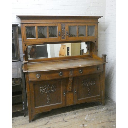 431 - An Arts and Crafts oak mirror backed sideboard, the upper section with convex glazed doors, with two... 