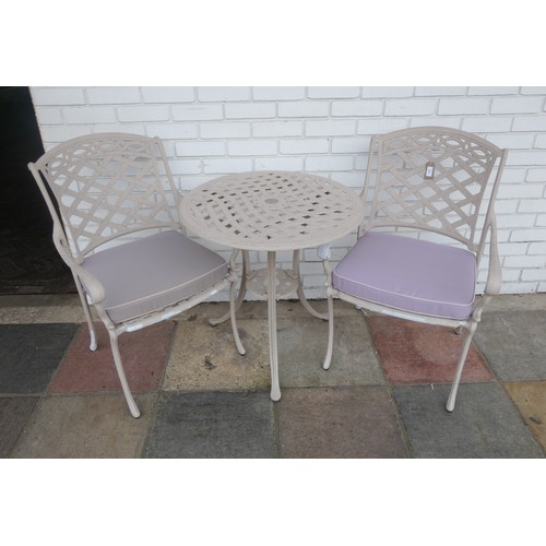 824 - A painted garden table and chairs with loose cushion seat coverings