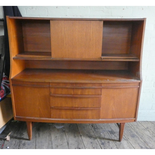 57 - A teak bow front high sideboard fitted shelves with drawers and cupboards under. 4'3