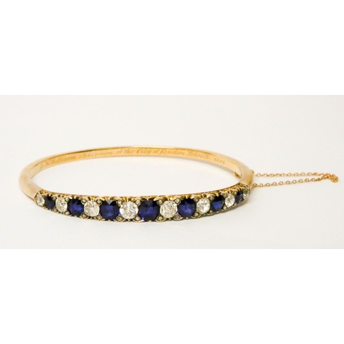 707 - An early 20th century old cut sapphire and diamond hinged bangle, set with seven circular sapphires ... 