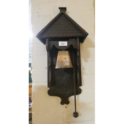 304 - A brass and oak cottage bell carved with a cockerel complete with beater