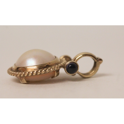 576 - A modern 9ct gold mabe pearl and cabochon sapphire pendant enhancer, the circular pearl within rope ... 