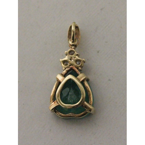 634 - A large emerald and diamond teardrop shaped pendant. The heart shaped emerald claw set with three br... 