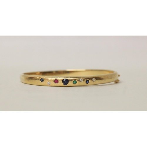 637 - A multi gem set 18ct yellow gold hinged bangle. Pave set with diamonds, sapphires, emerald and ruby,... 