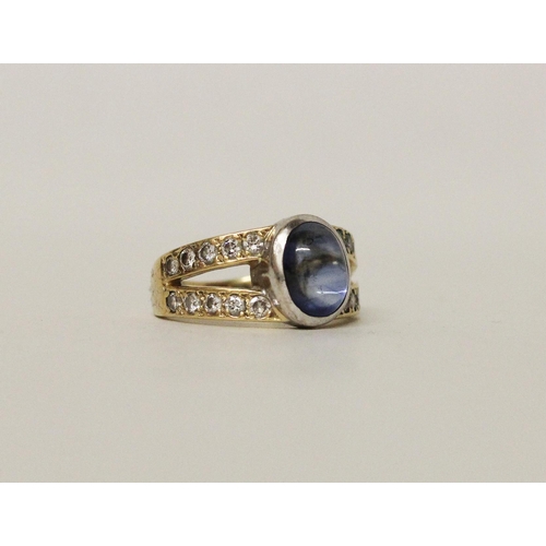 639 - A star sapphire and diamond ring, the oval sapphire bifurcated pave diamond set shoulders. On 18ct y... 