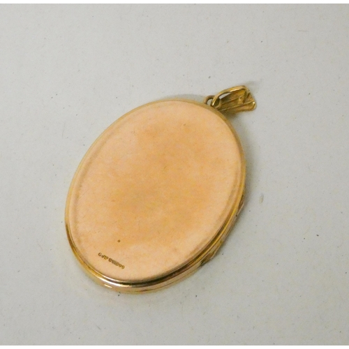 651 - A large oval 9ct gold locket, with wavy design to the front. Hallmarked. 14.5g, 52mm long including ... 