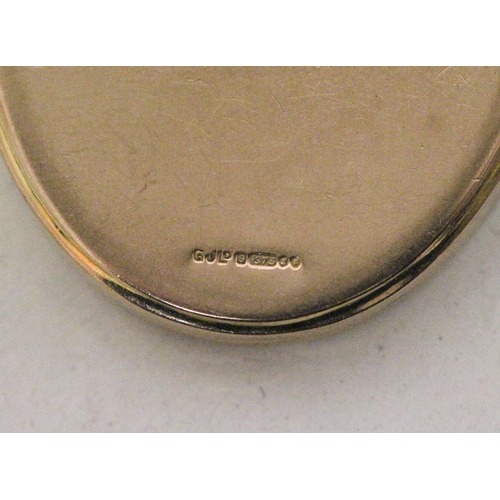 651 - A large oval 9ct gold locket, with wavy design to the front. Hallmarked. 14.5g, 52mm long including ... 