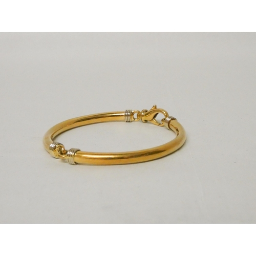 655 - An 18ct yellow gold bangle, of hinged jointed design, with large lobster clasp. Marked 750. Gross we... 