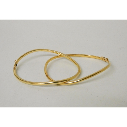 657 - A pair of 18ct yellow gold shaped bangles, of bespoke hinged design, stamped 18ct. Gross weight 31.2... 