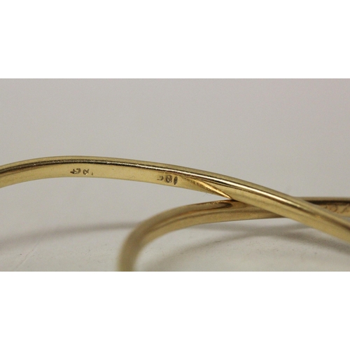 657 - A pair of 18ct yellow gold shaped bangles, of bespoke hinged design, stamped 18ct. Gross weight 31.2... 