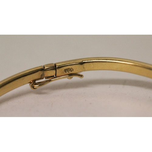 657 - A pair of 18ct yellow gold shaped bangles, of bespoke hinged design, stamped 18ct. Gross weight 31.2... 