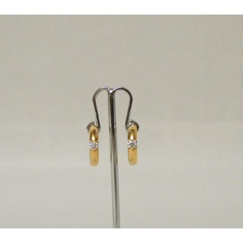 661 - A pair of 18ct yellow gold and diamond huggie hoop earrings, each set with a 15 point brilliant cut ... 