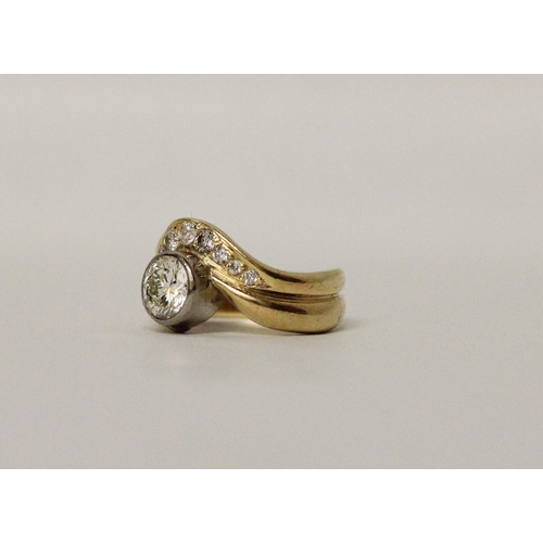 662 - A diamond ring, with a rub over set circular brilliant cut diamond within shaped bands of 18ct yello... 