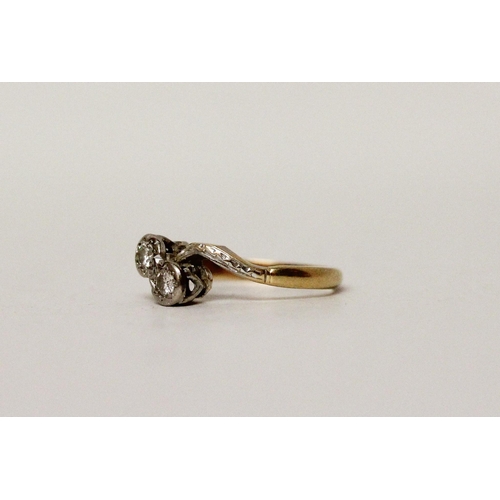 670 - A vintage 18ct & platinum mounted two stone cross over deign diamond ring. Band marked 18ct. Ring si... 