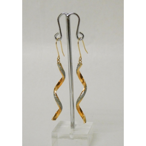 673 - A pair of modern 9ct gold and diamond cut twist drop earrings. On wires, marked 375. 56mm long inclu... 