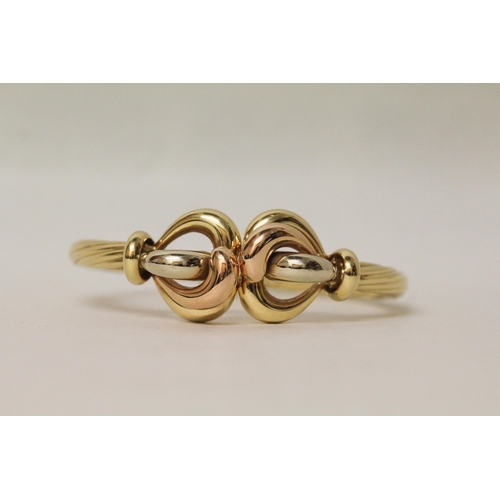 705 - Good quality modern 18ct tri-colour gold hinged bangle, with central knot designing three differing ... 