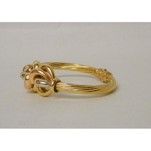 705 - Good quality modern 18ct tri-colour gold hinged bangle, with central knot designing three differing ... 