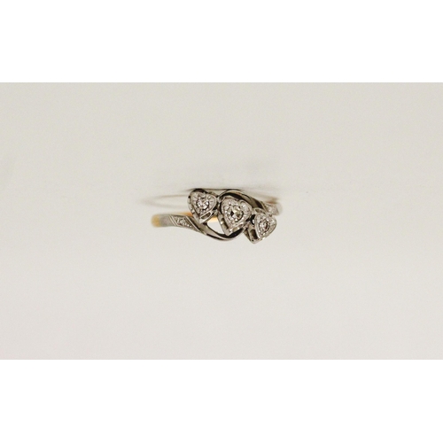 718 - A vintage 18ct gold and platinum mounted three stone diamond ring, in heart shaped illusion setting.... 