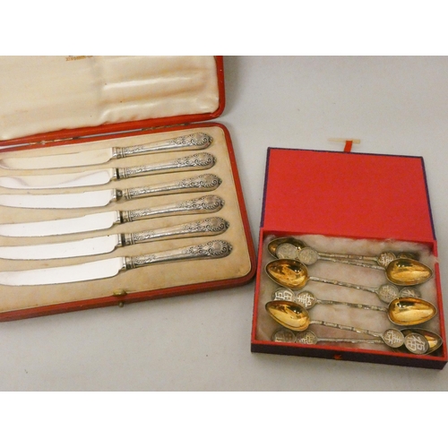 505 - A set of six Chinese white metal tea spoons with gilded bowls and a set of six silver handled pastry... 