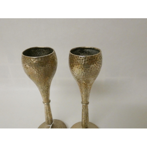 507 - A pair of silver vases on weighted bases, 17 cms tall, together with three silver napkin rings and s... 