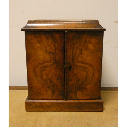 395 - A Victorian figured walnut two door cabinet with three interior drawers. 11 1/2