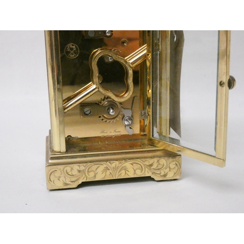 266 - A French gilt brass carriage clock with engraved carrying handle and case complete with key