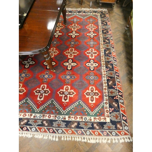 467 - A large red patterned and bordered wool pile Persian carpet 11'3